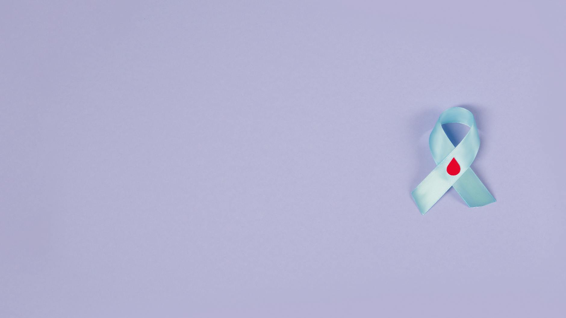 Nie tylko pieniądze: jak prowadzić skuteczną kampanię zbiórki krwi i rejestracji dawców Fioletowa wstążka z kroplą krwi na tle symbolizująca akcję dawstwa krwi
