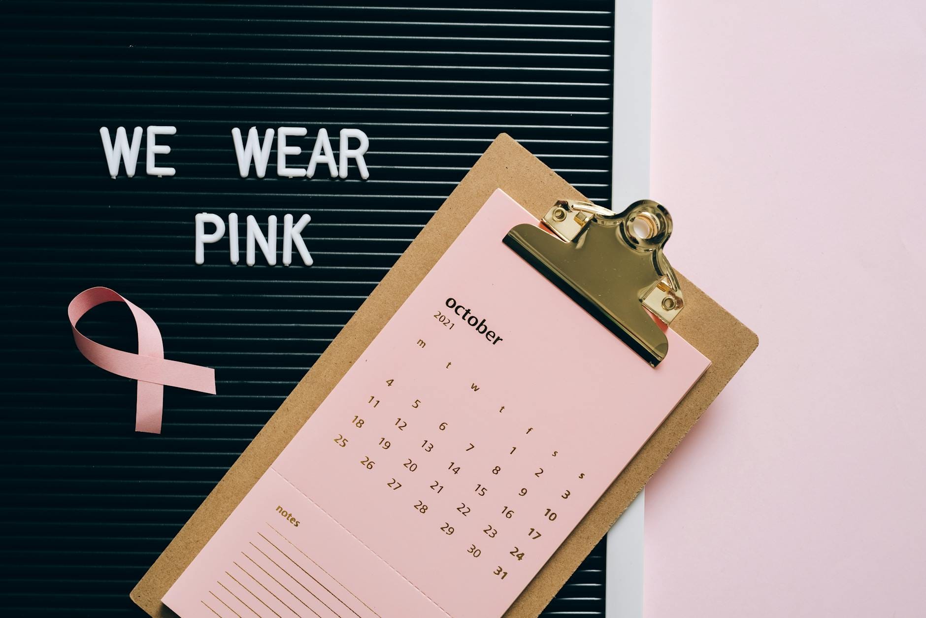 Kalendarz z październikiem i różową wstążką symbolizującą raka piersi