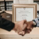 Co daje certyfikacja NGO w Europie i jak wpływa na zaufanie darczyńców Uścisk dłoni nad dyplomem potwierdzającym certyfikację i zaufanie